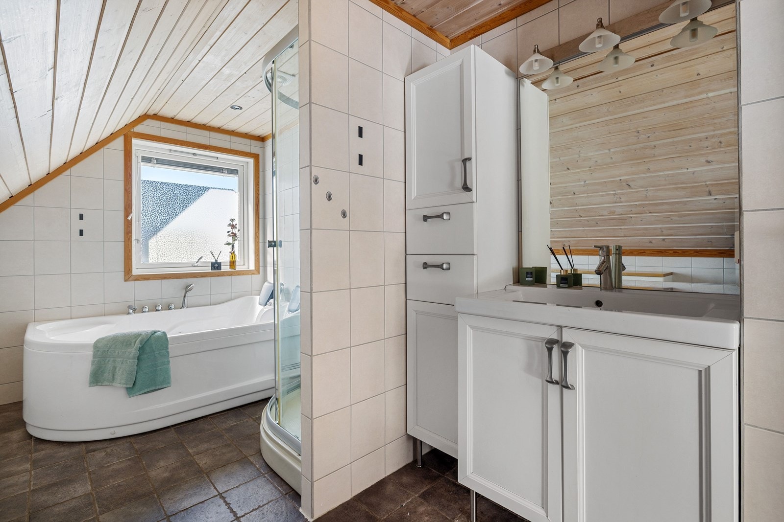 Flislagt bad med varme i gulvet. Badet her baderomsinnredning med veggskap og underskap og heldekkende servant. Speil med lys i overkant. Galleribilde