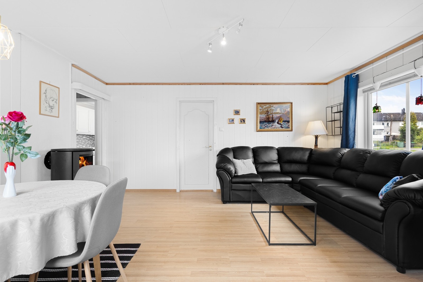 Stuen er innredet med sofagruppe, spisestue og vedovn. Galleribilde