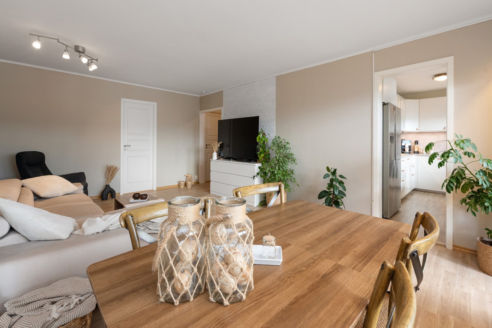 Stuen har god plass til sofamøblement, TV-seksjon og en velegnet spiseplass ved kjøkkensonen. Galleribilde