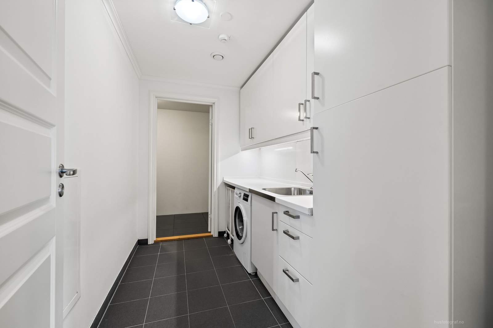 Separat vaskerom med skapinnredning og nedfelt utslagsvask Galleribilde