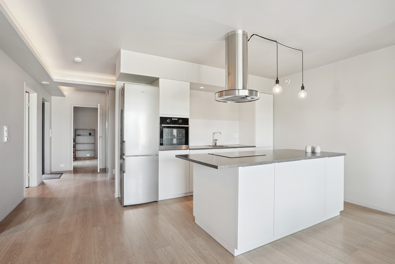 Kjøkkeninnredning med hvite glatte fronter. Det er laminat benkeplate. Galleribilde