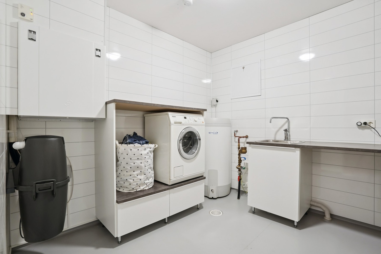 Vinyl på gulv og baderomsplater på vegger på vaskerommet. Innredning med nedfelt skyllekar og opplegg for vaskemaskin. Montert ventilasjonsanlegg Galleribilde