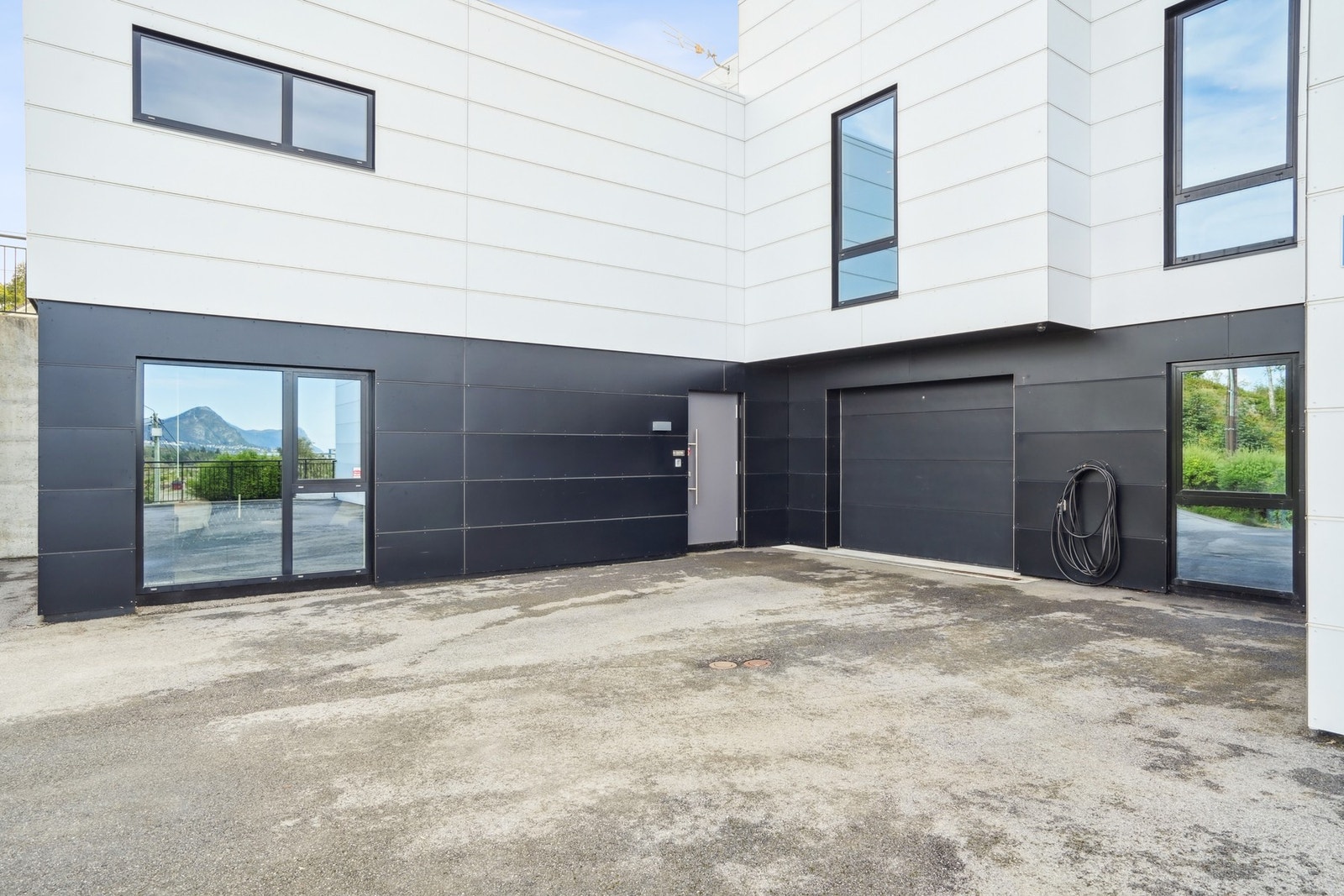 Asfaltert innkjørsel til utleiedelene. Garasjeplass som tilhører utleiedelen. Galleribilde