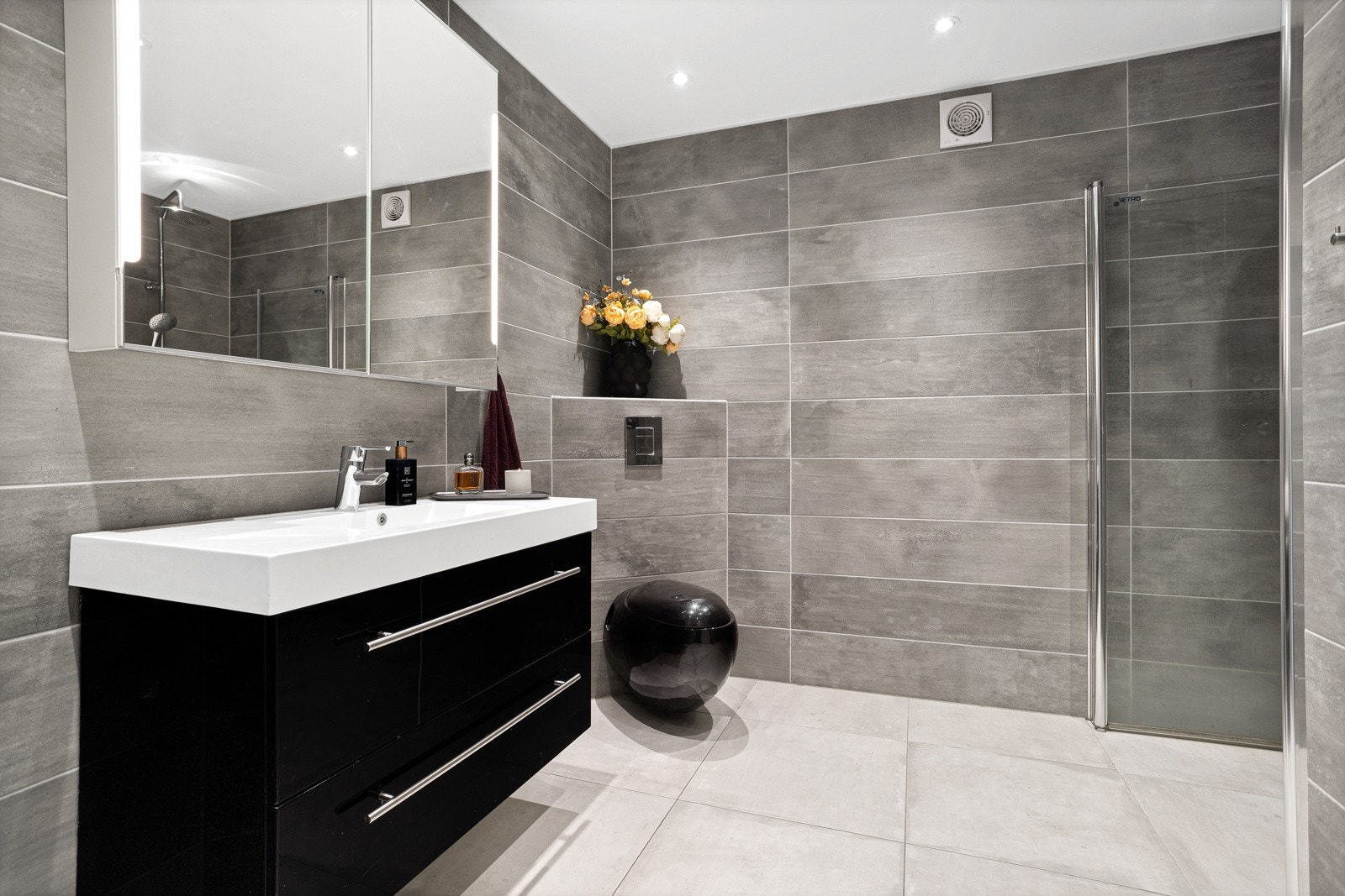 Flott bad i 1.etg. som er innredet med toalett, baderomsinnrending med servant og dusjnisje med dobbel dusj og glassvegg. Galleribilde