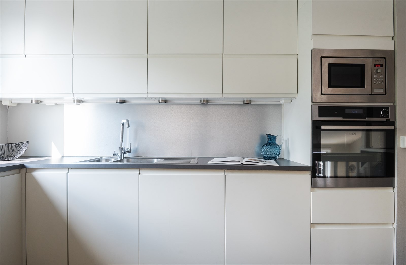 Kjøkkeninnredning fra HTH med glatte fronter. Laminert benkeplate med nedfelt platetopp og oppvaskkum med ettgreps svingbart blandebatteri. Galleribilde