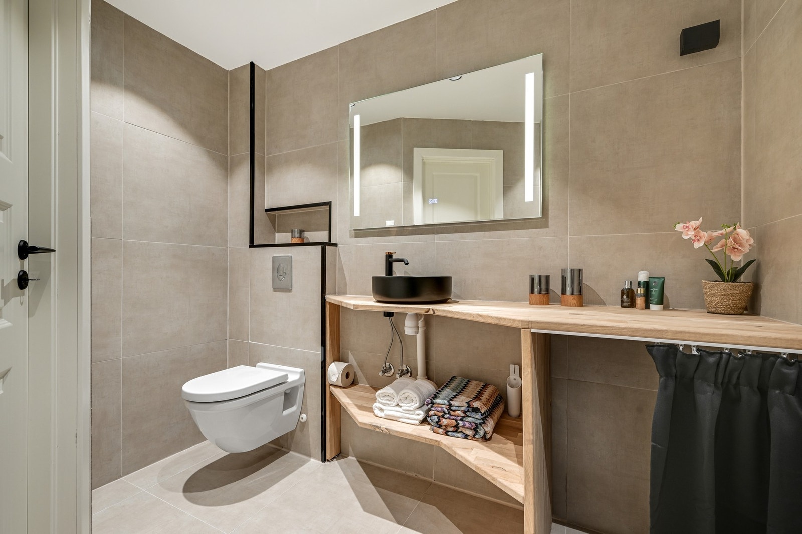 Delikat bad oppgradert i 2024 med vegghengt toalett, moderne servant og flislagte overflater Galleribilde