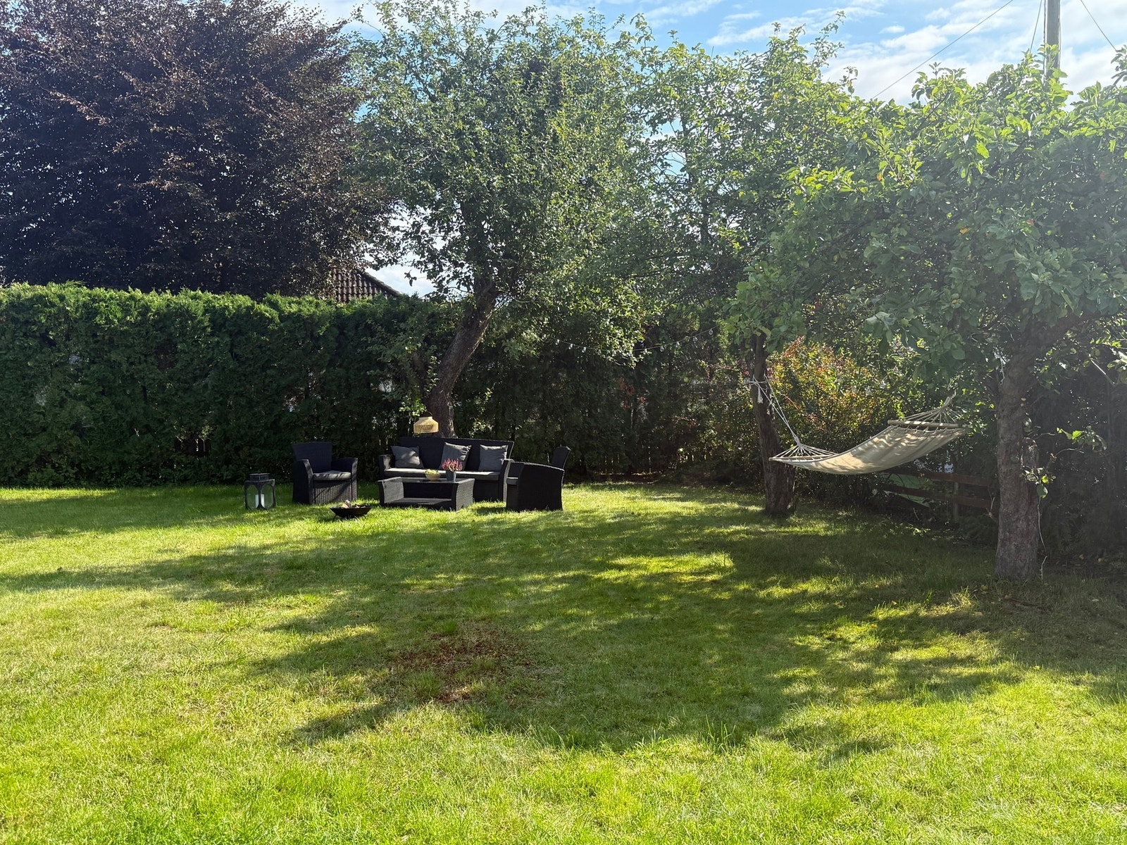 Trivelig hage med plen og beplantning. Galleribilde