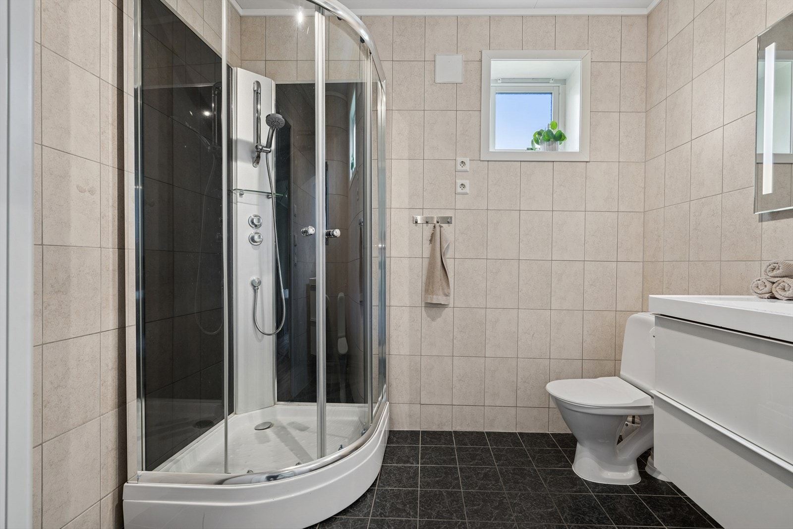 Badet er flislagt og utstyrt med dusjkabinett. Vindu for god utlufting Galleribilde