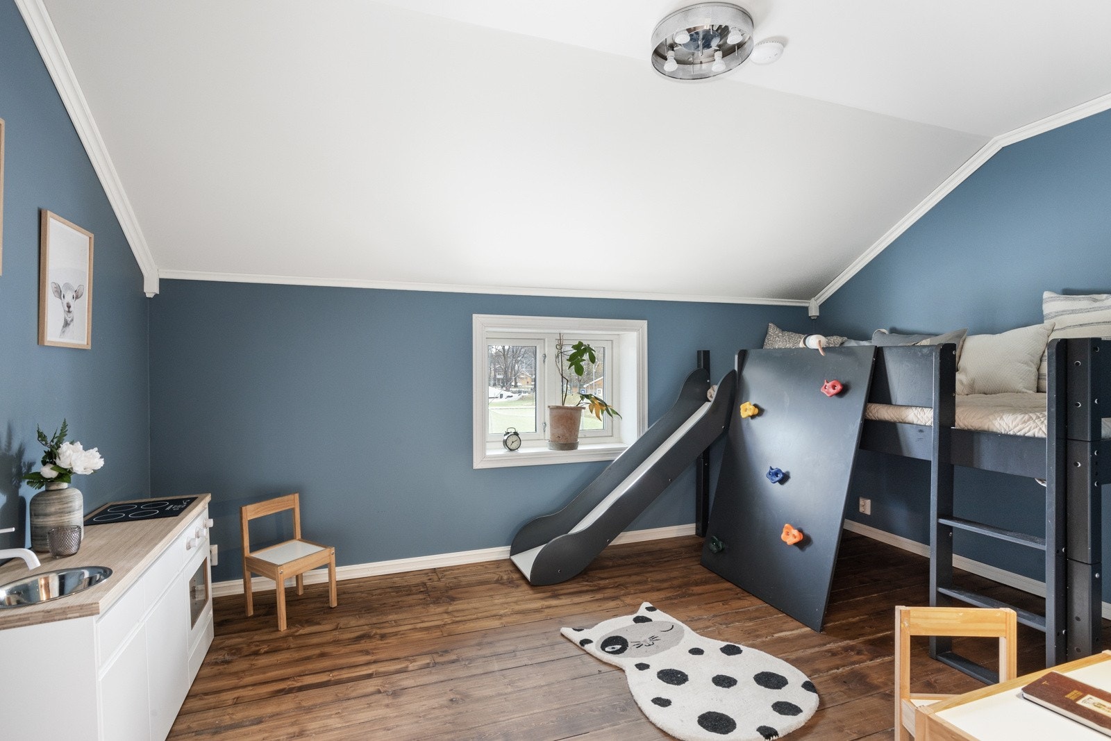 Lekefullt og fargerikt blått barnerom med plass til både lek og søvn. Galleribilde