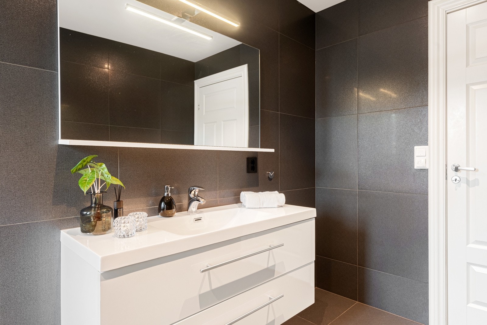 Fra hallen er det adkomst til badet i etasjen, og vegg i vegg finner du separat vaskerom Galleribilde