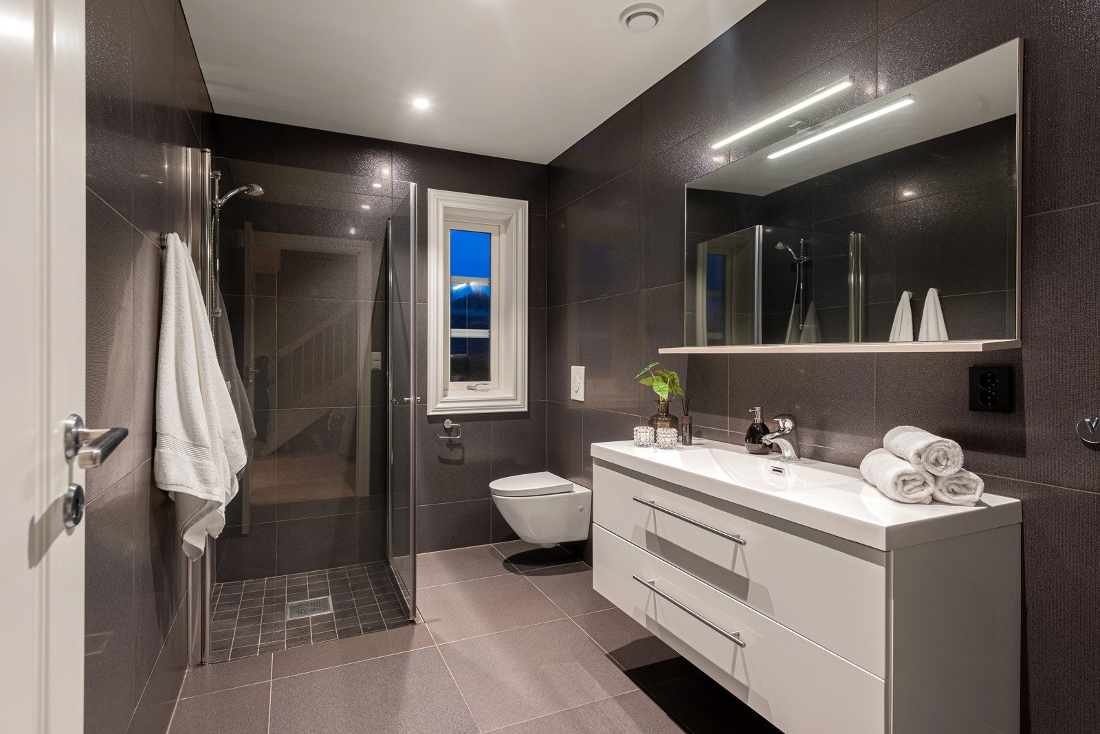 Det er ett bad i hver etasje, som begge har et fint og luksuriøst utseende med svarte fliser og hvite detaljer Galleribilde