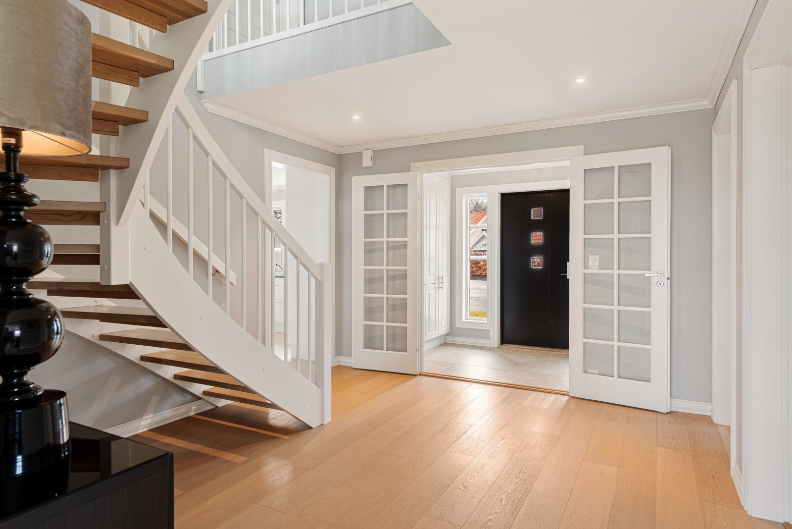 Fra entreen kommer du videre inn hallen hvor du har enstavs parkett og trappeåpningen til 2.etasjen gir deg en fantastisk følelse av det åpne rommet Galleribilde