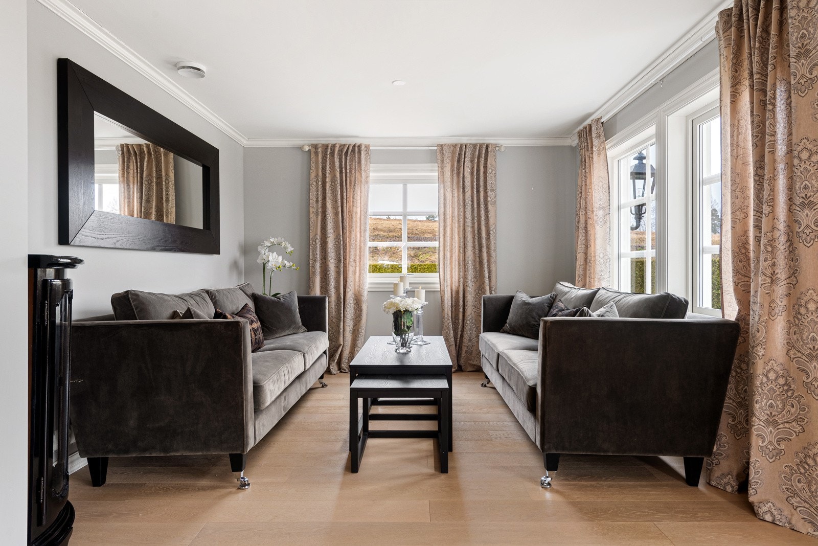 Den lyse parketten, de lyse veggfargene og de store vindusflatene skaper et åpent og innbydende oppholdsrom Galleribilde