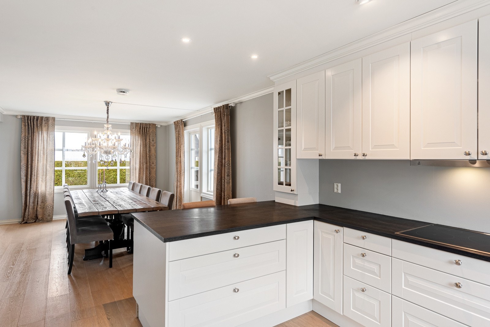 På kjøkkenet finner du lys innredning med profilerte fronter, og den ekstra innredningen skaper et naturlig skille mellom kjøkkenet og spiseplassen Galleribilde