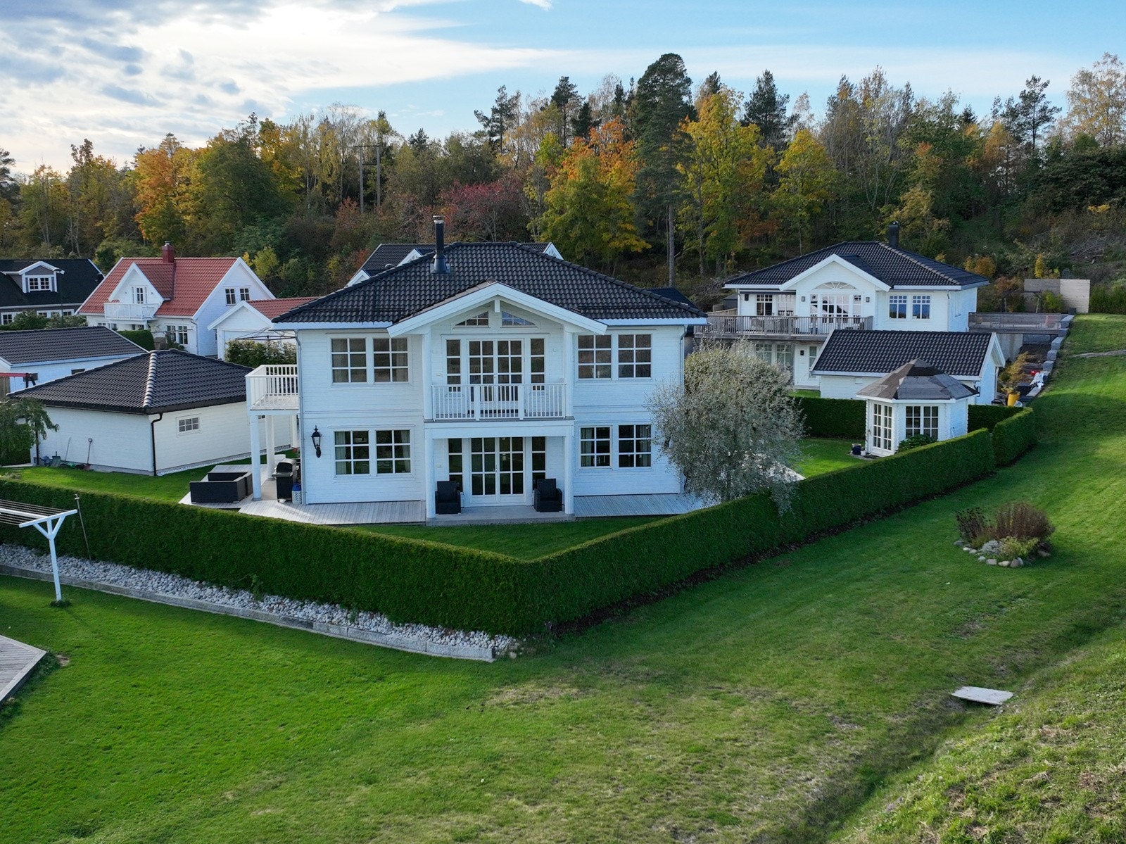 Her har du mange flotte uteplasser du kan benytte deg av, og med hage og hekk rund huset har du en trygg og god plass for både store og små Galleribilde