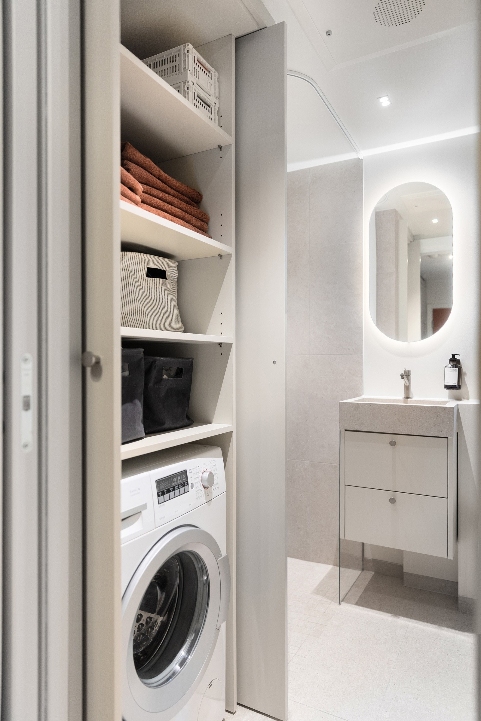 Smart plassbygget skap med opplegg for vaskemaskin og smarte hyller over. Galleribilde