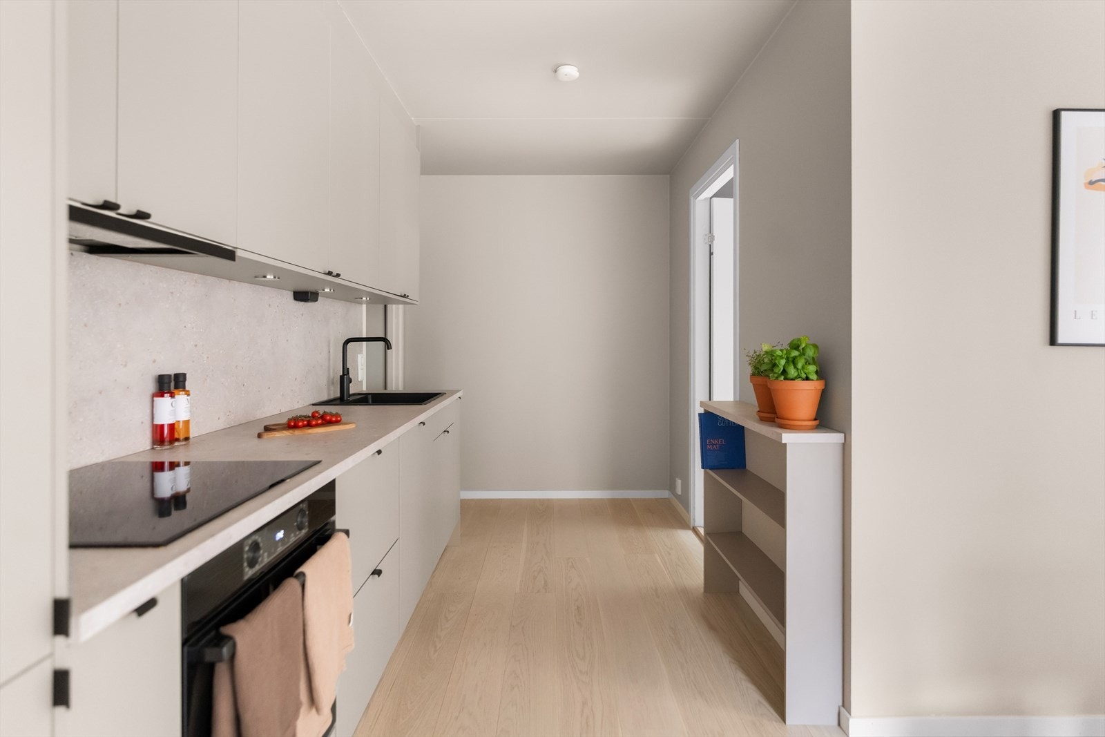 Innredningen har skap med glatte fronter, samt laminat benkeplate med nedfelt kum. Kjøkkeninnredningen fra Norema byr på rikelig med benk- og skapplass. Kjøkkeninnredningen var ny i 2023. Galleribilde