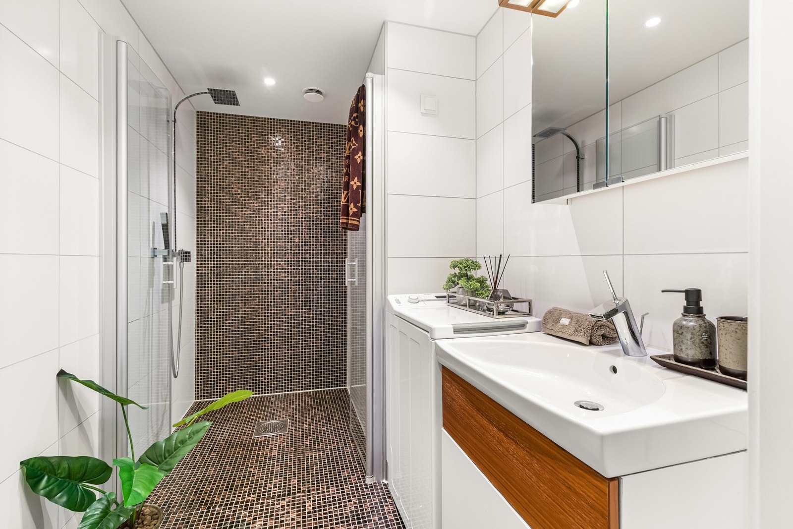 Lekkert bad av god størrelse med downlights, gulvvarme, vegghengt høyskap og opplegg til vaskemaskin Galleribilde