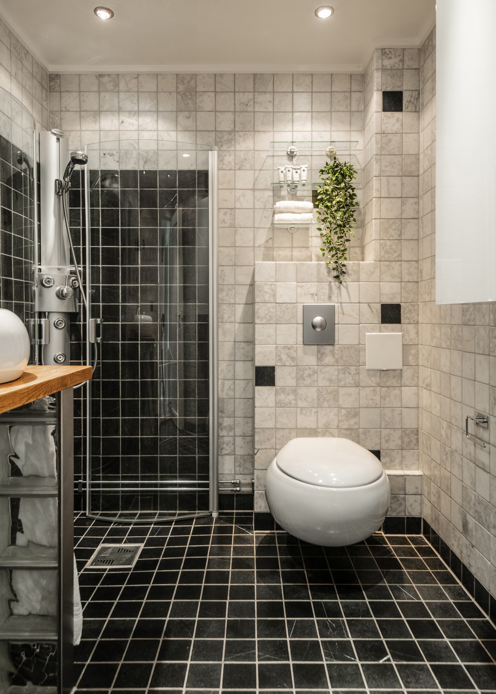 Innredningen består av vegghengt toalett, servant med speil og lys, veggskap samt dusjhjørne med inn- og utadslående glassdører. Galleribilde