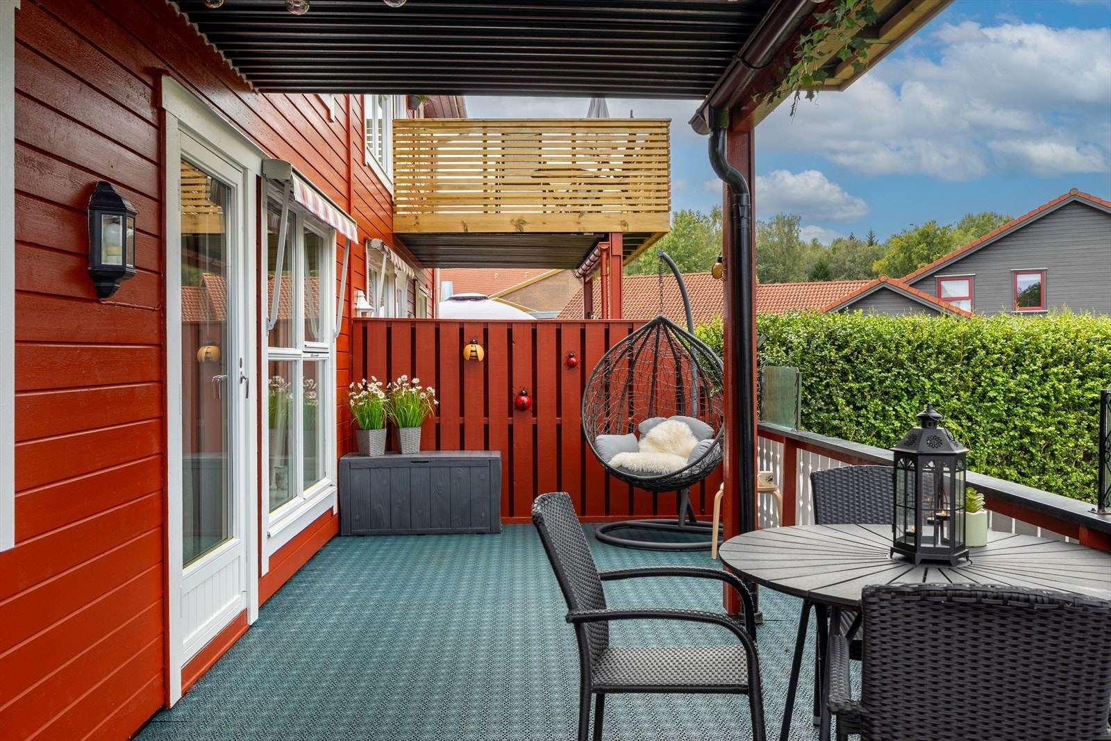 Terrassen er delvis takoverbygget av balkongen over som bidrar til en lun og hyggelig uteplass som kan brukes store deler av året, uansett vær. Galleribilde