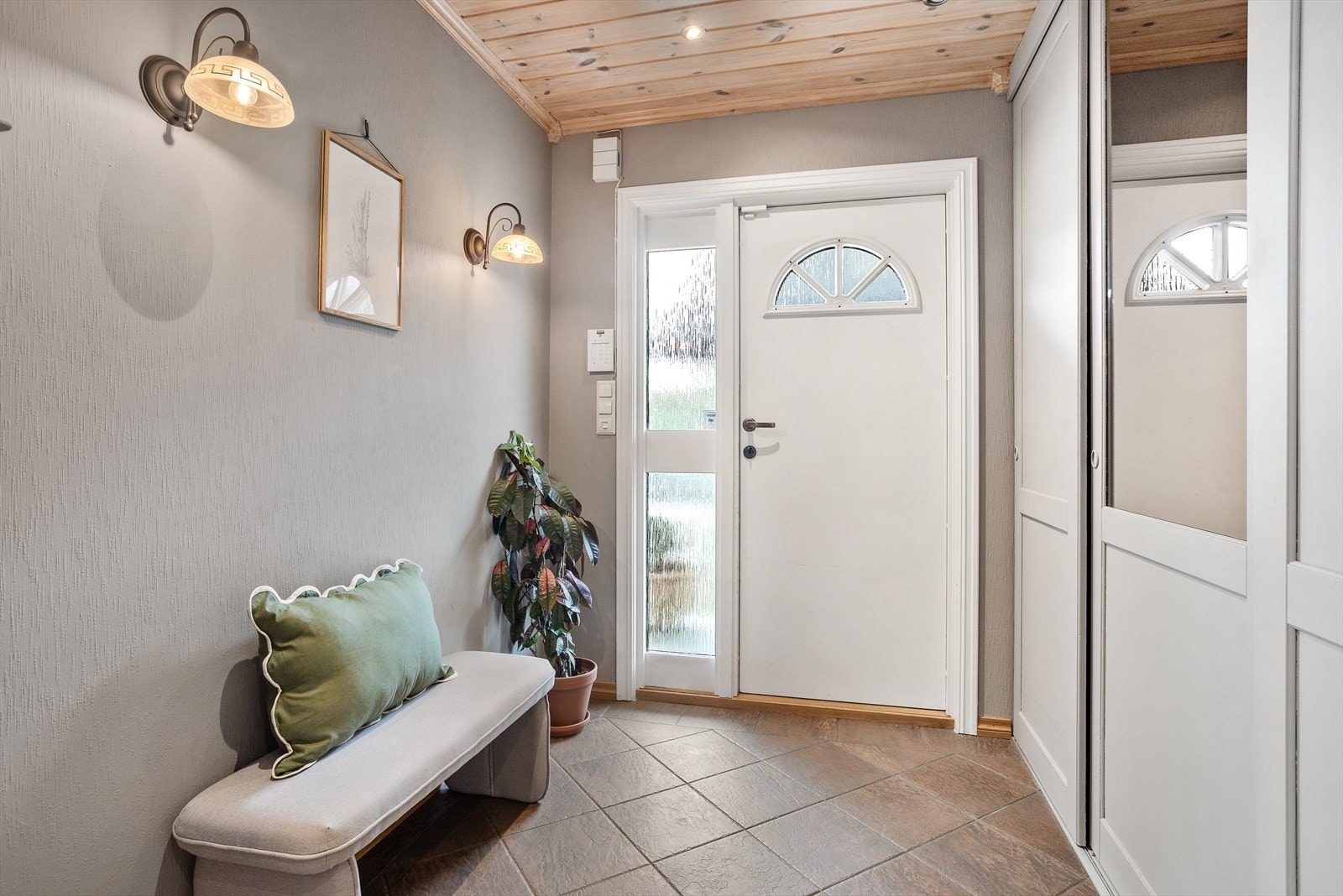 Entrè med flislagt gulv med varme og romslig skyvedørsgarderobe. Galleribilde