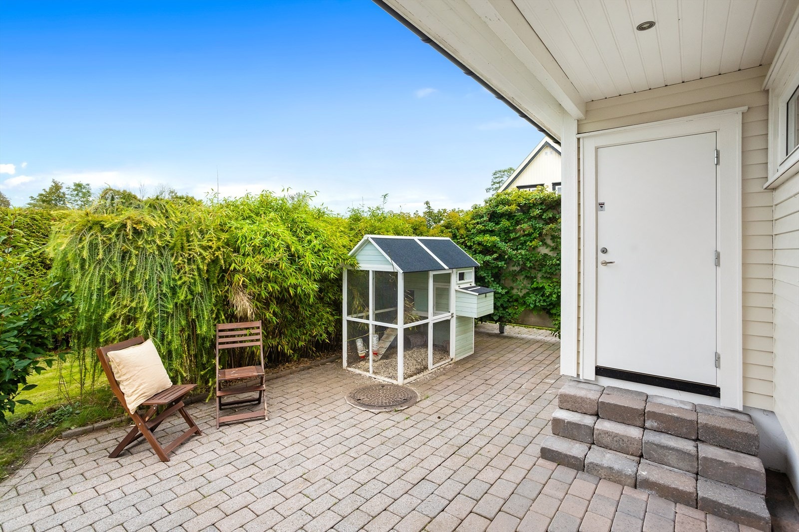 Koselig uteplass i bakhagen. Døren fører inn til badstuen. Galleribilde