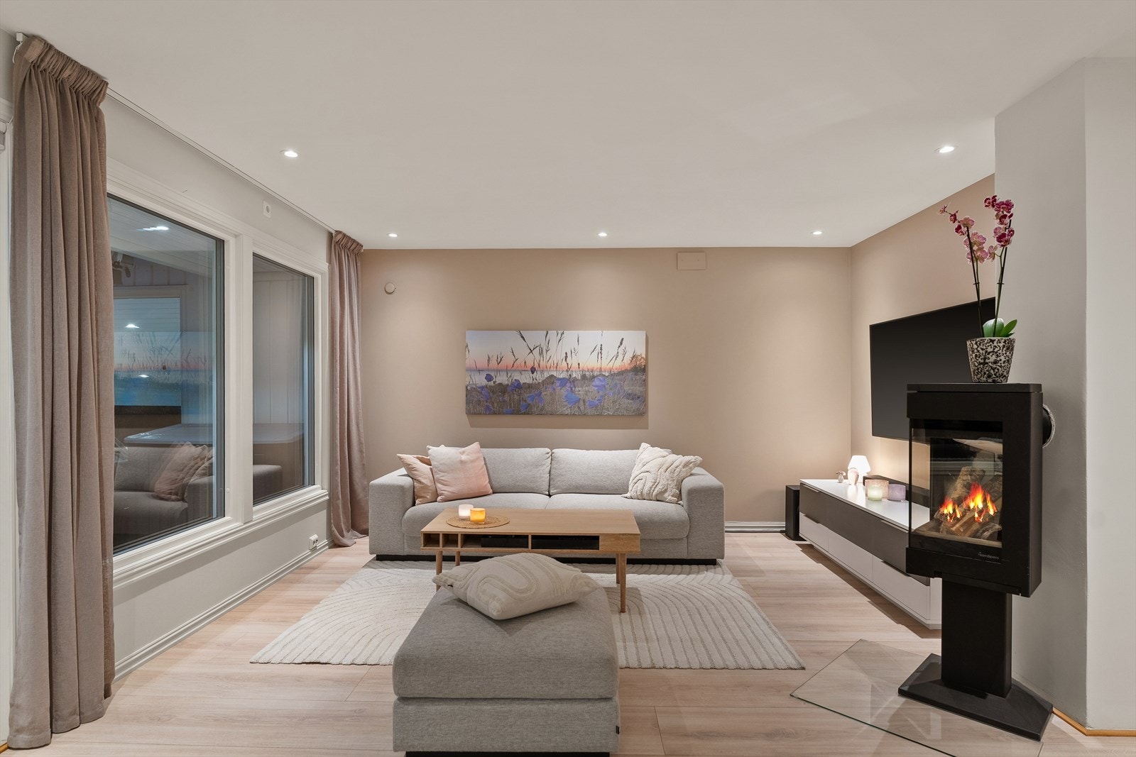 Overflatene er holdt i et harmonerende fargepalett med lys, enstavs laminat og vegger malt i en kombinasjon av beige og hvit. Galleribilde