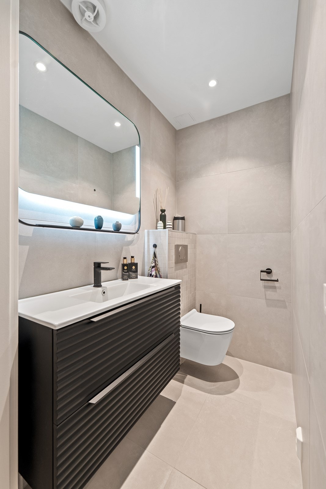 Toalettrommet har store moderne fliser på gulv og vegger, samt varme i gulvet og downlights i himling. Galleribilde