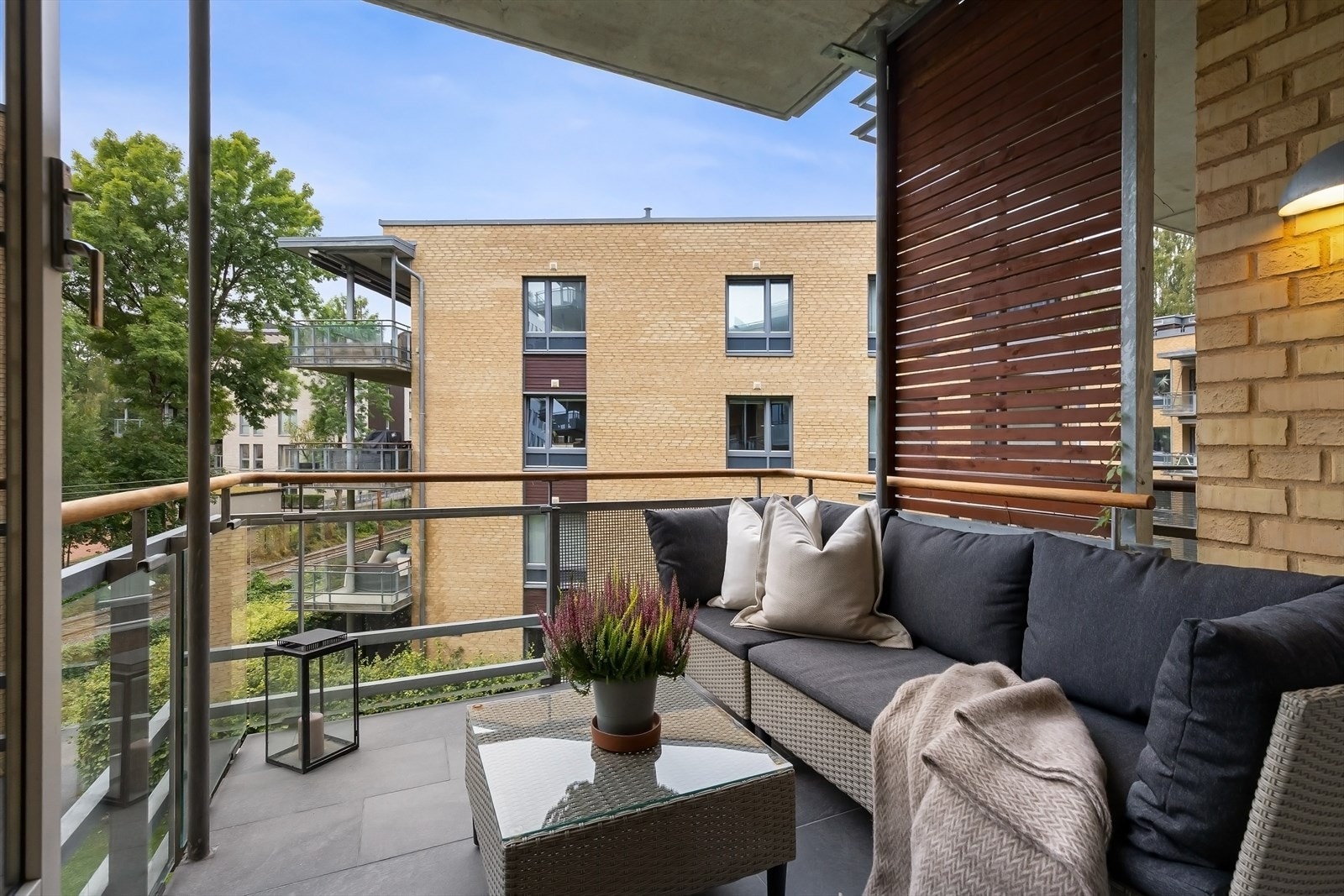 Med flislagt gulv, moderne glassrekkverk, og god plass til både bord og stoler, fungerer balkongen som en herlig forlengelse av stuen. Galleribilde