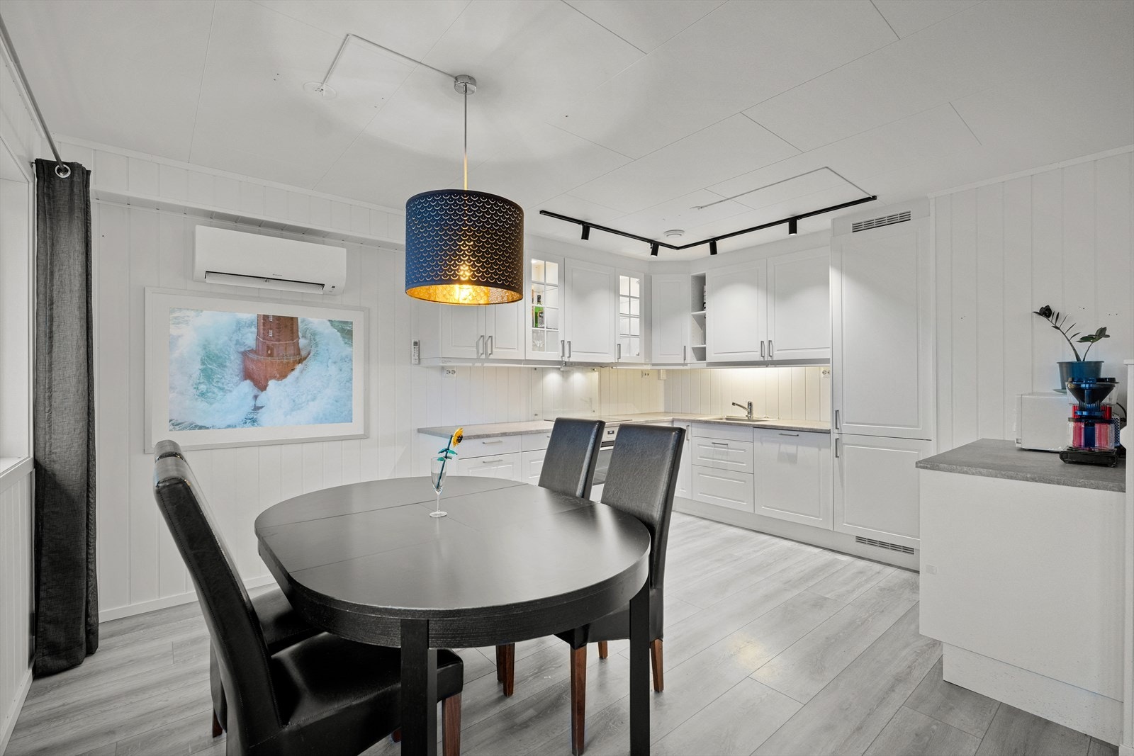 Lyst kjøkken med integrerte hvitevarer. Det er montert varmepumpe på kjøkkenet. Galleribilde