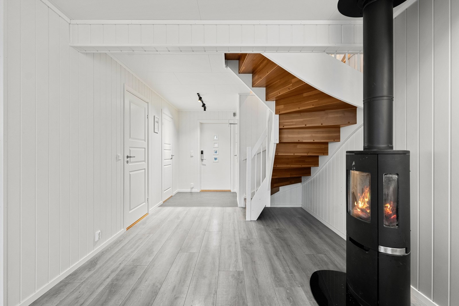 Lys entré med flislagt gulv, mellomgang med trapp til 2.etg og peisovn. Galleribilde