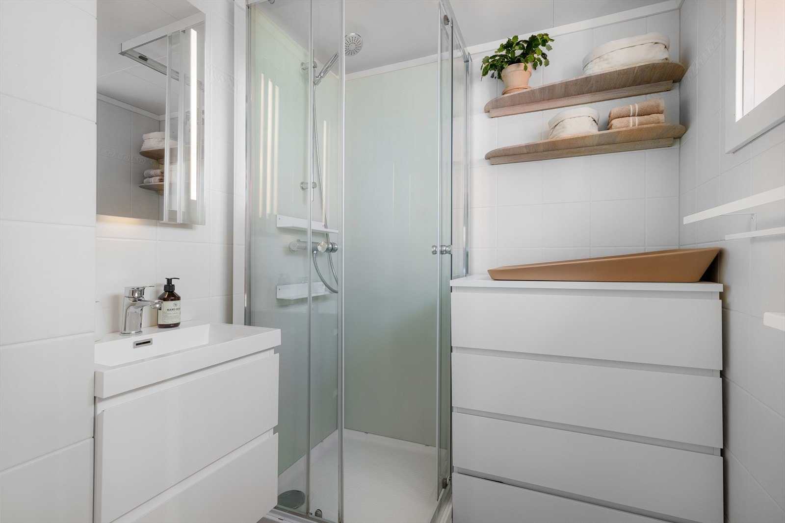 Badet ligger lett tilgjengelig på samme etasje som soverommene. Rommet ble modernisert i 2024 med nye flis på flis på gulv og ny baderomsinnredning. Flere i borettslaget har slått sammen WC-rom og bad for å få et ekstra stort bad. Galleribilde