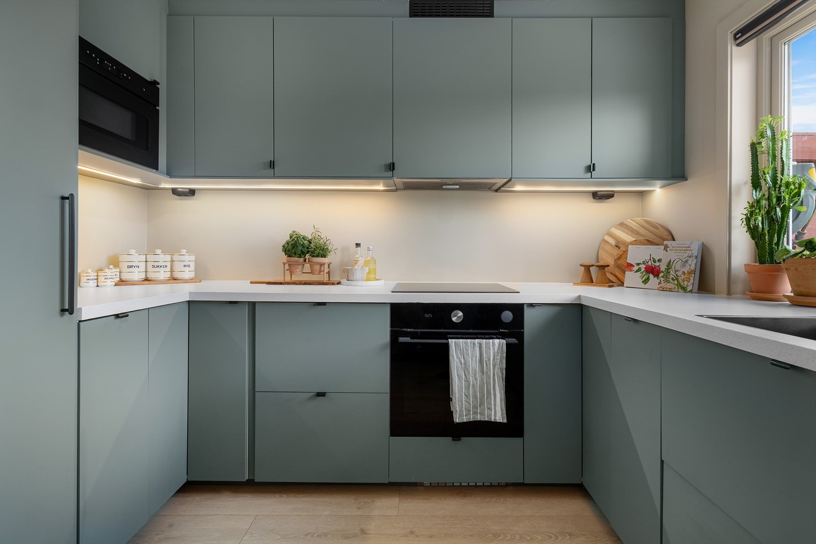 Kjøkkeninnredningen i dypgrønn farge har et stilfullt og sofistikert uttrykk, og ble innstallert i 2021. Det er Integrert komfyr med induksjons platetopp, mikrobølgeovn, oppvaskmaskin, kjøleskap som høyskap og fryseskap under benk. Galleribilde