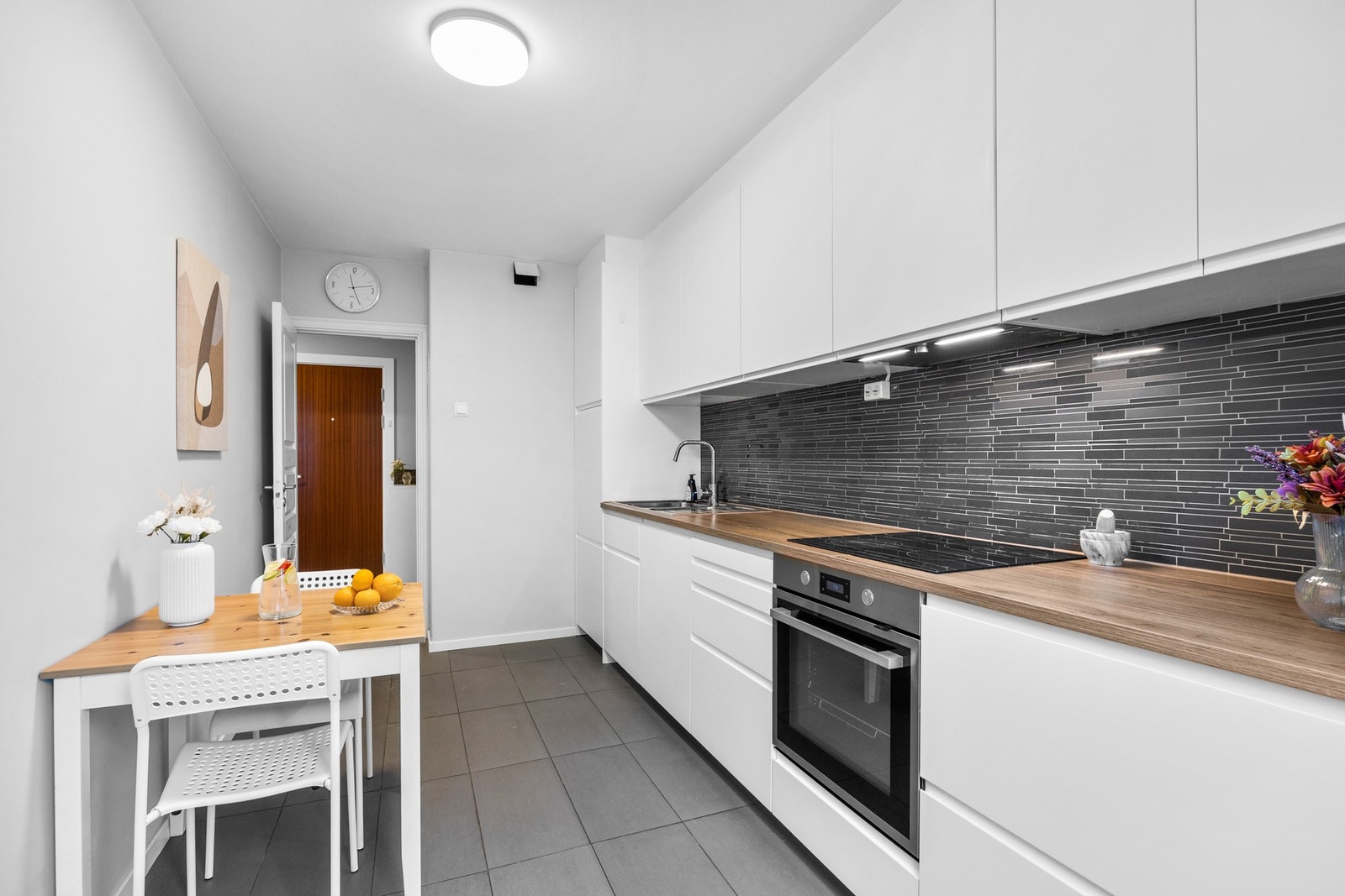 Kjøkkenet ble pusset opp i 2019. Innredningen består av glatte, folierte fronter, laminat benkeplate med nedfelt kum. Galleribilde