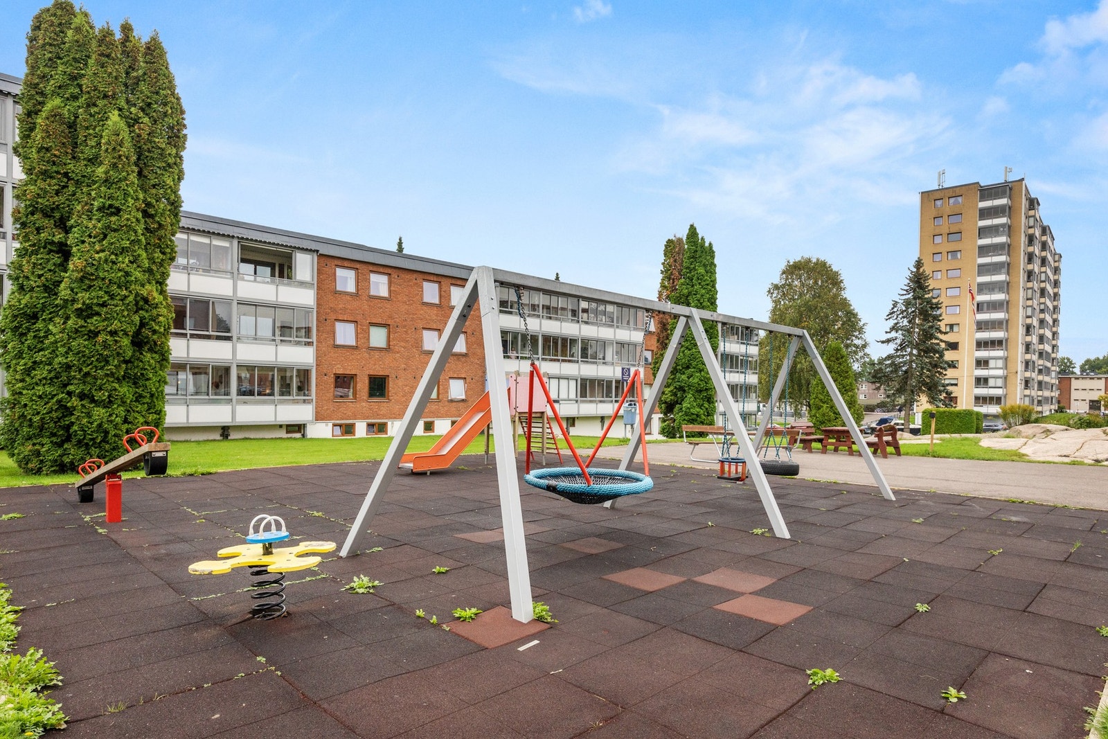 Tomten er pent opparbeidet med asfalterte internveier, grøntområder, beplantning, benker og lekeapparater. Galleribilde