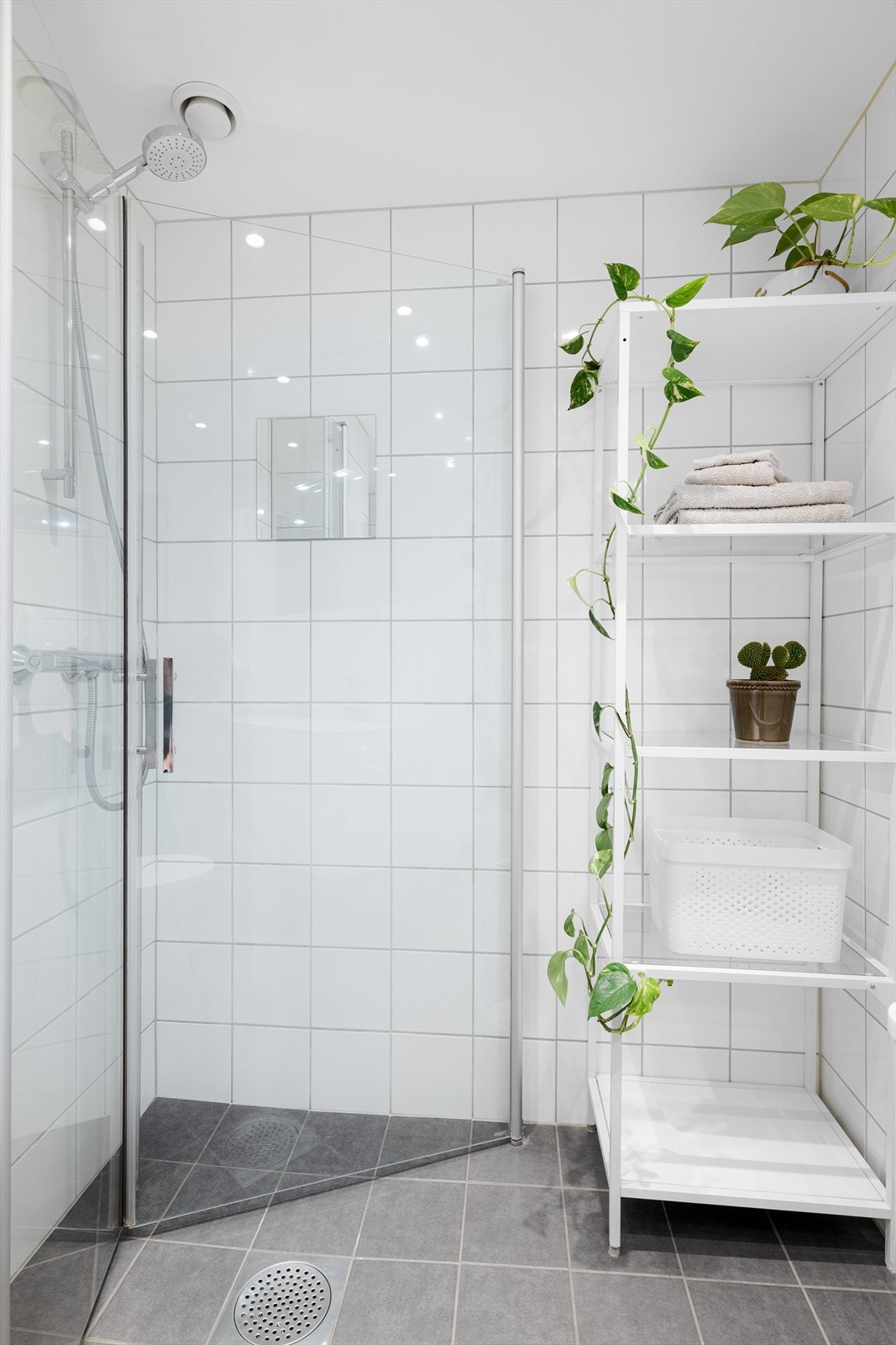 Praktisk dusjhjørne med svingbare glassdører og behagelig gulvvarme for økt komfort. Galleribilde