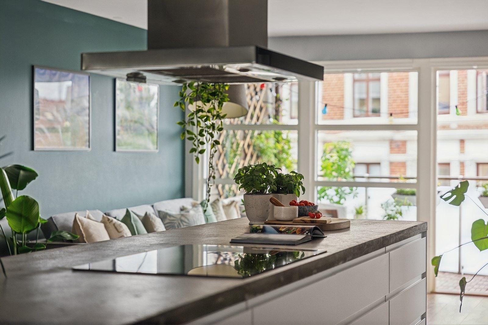 Kjøkkenøyen deler rommet elegant. Denne har en spesialtilpasset betongbenkeplate, støpt fra bunnen av og fraktet opp i leiligheten av åtte personer i sin tid. Den massive og solide platen harmonerer perfekt med resten av kjøkkenets moderne uttrykk. Galleribilde