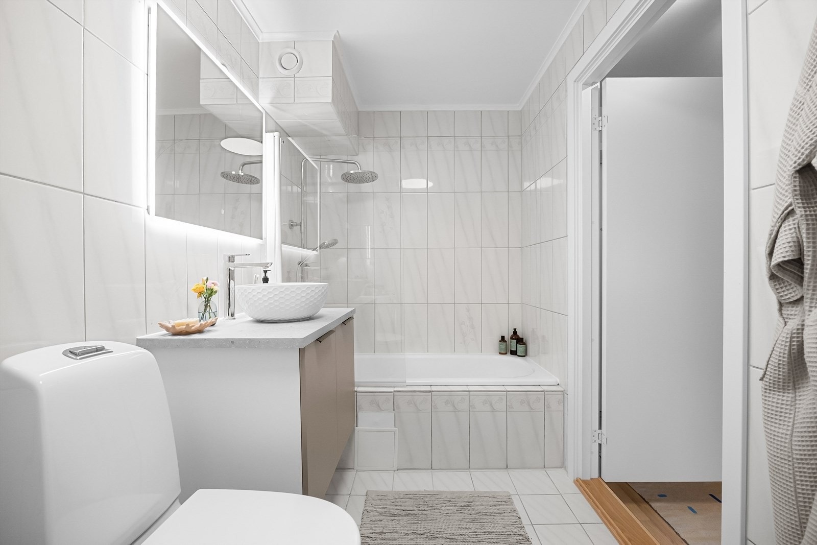 Badet har badekar, toalett, servant og speilskap. Galleribilde