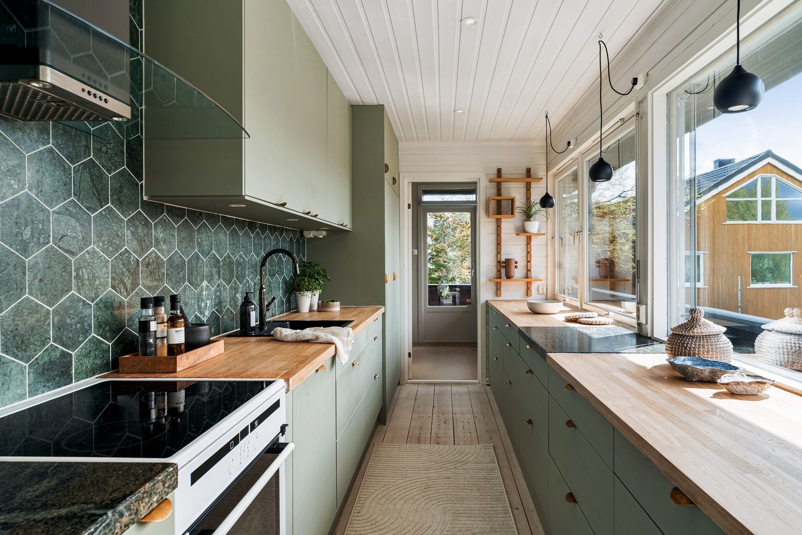 Kjøkkenet har en praktisk løsning som gir store arbeidsflater og godt med lagringsplass. Galleribilde