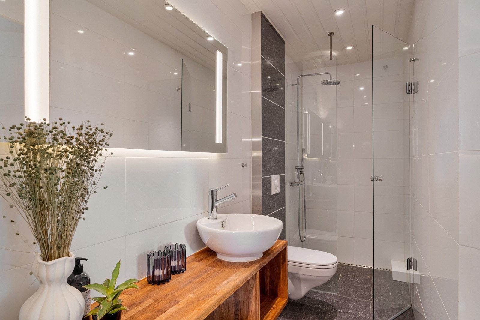 Badet i sokkelen fremstår som moderne og har varme i gulv Galleribilde