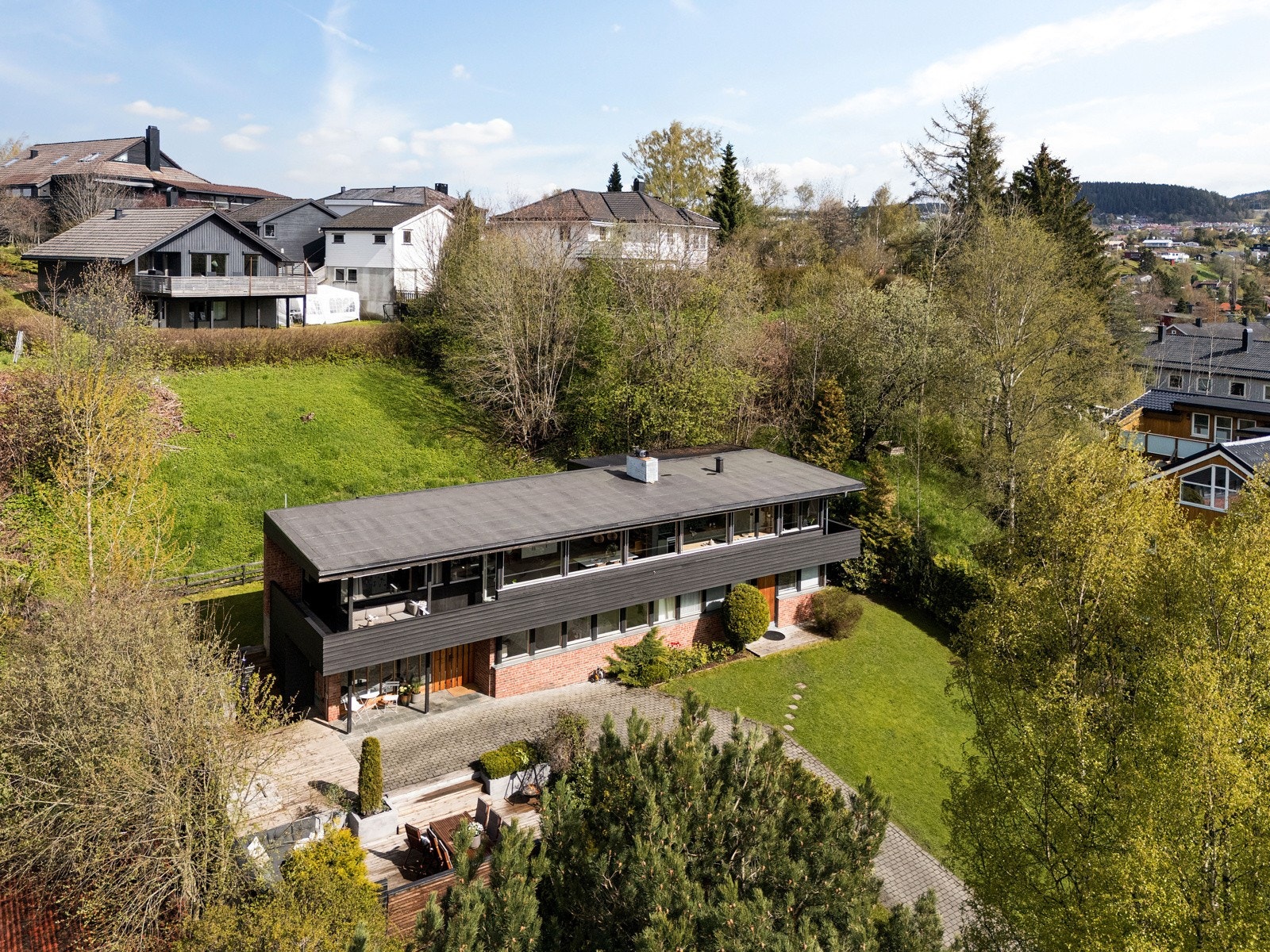 Boligen har en skjermet beliggenhet på Sunnland. Her ligger den tilbaketrukket, øverst på tomten som gir fritt utsyn. Galleribilde