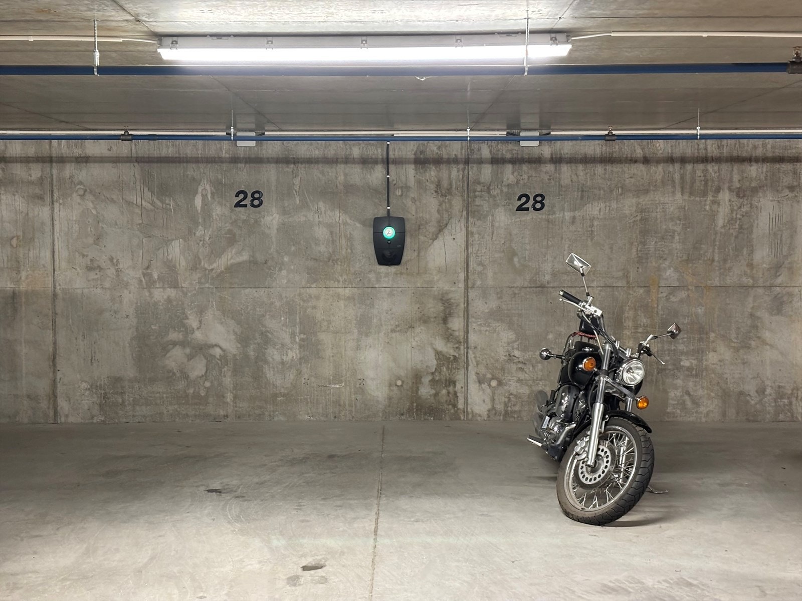 Boligen har to garasjeplasser i felles garasje, med el-billader i midten. Galleribilde