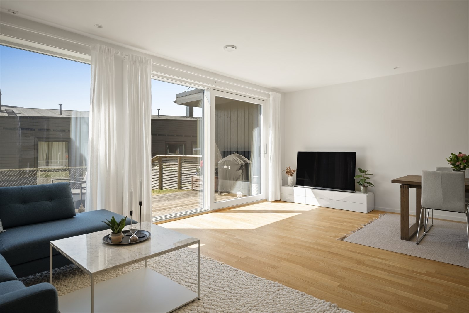 Store vinduer i stue byr på rikelig med naturlig lys. Galleribilde