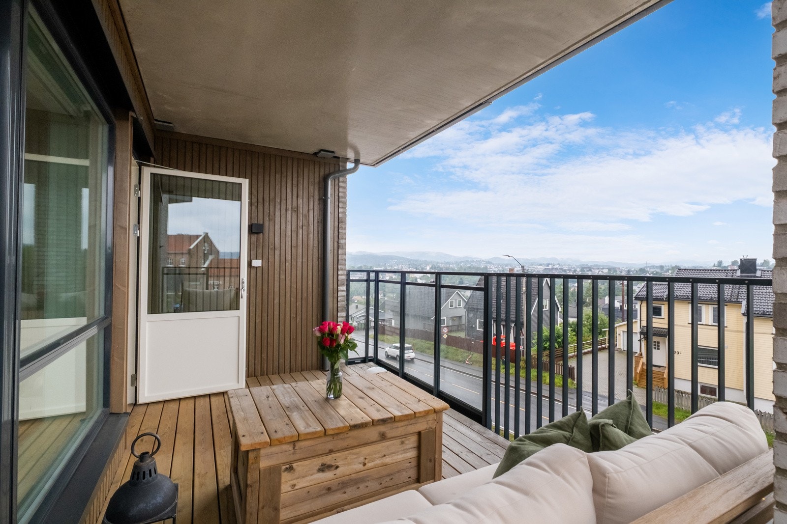 Lun uteplass fra stue med overbygg fra balkongen over. Galleribilde