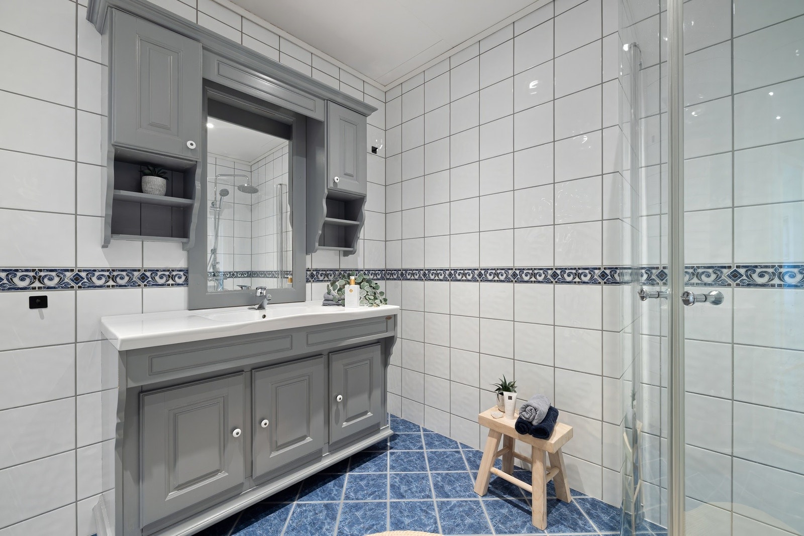 Dusjhjørne med foldedører i herdet glass samt dusjgarnityr med takdusj og hånddusj. Galleribilde