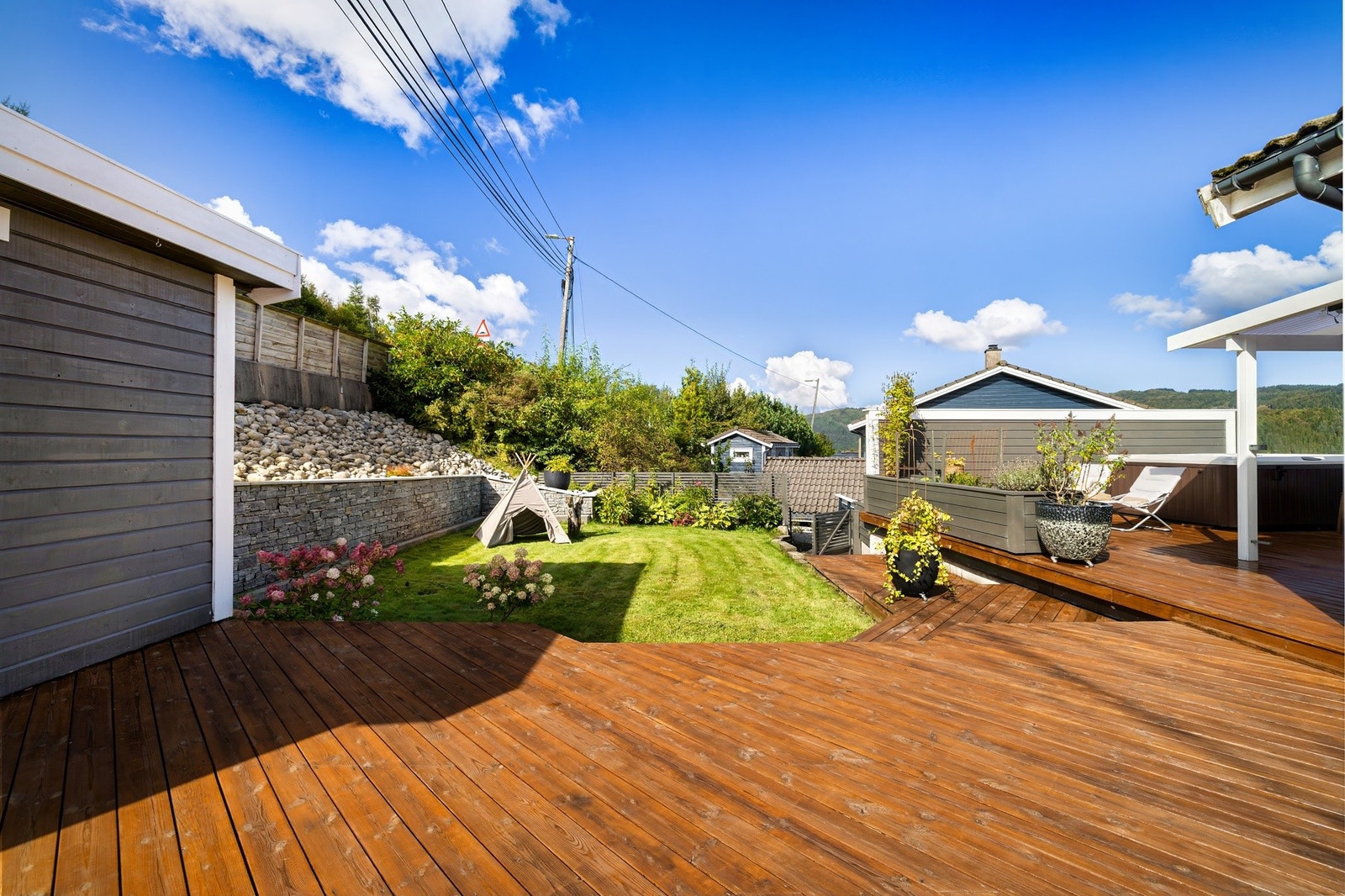 Fin overgang fra terrassen til plenen. Nivåmur i naturstein ble bygget i 2015. Galleribilde