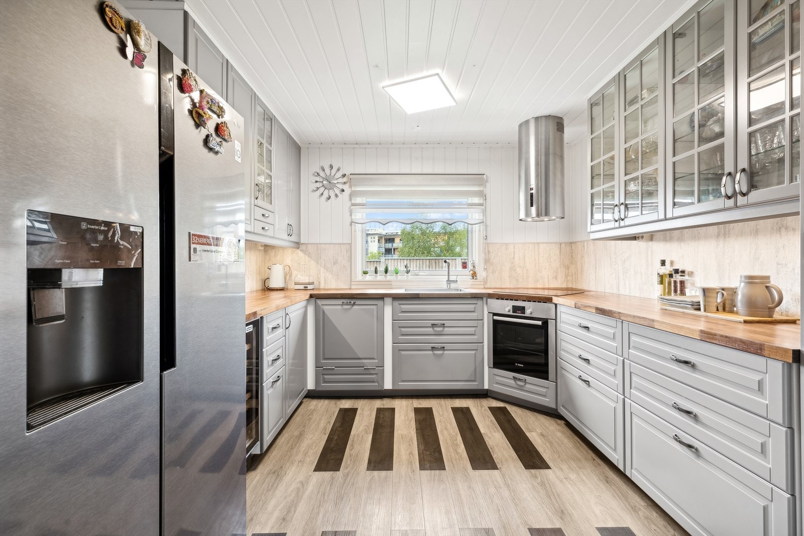 Kjøkkeninnredning med profilerte fronter, og belysning under overskap. Galleribilde