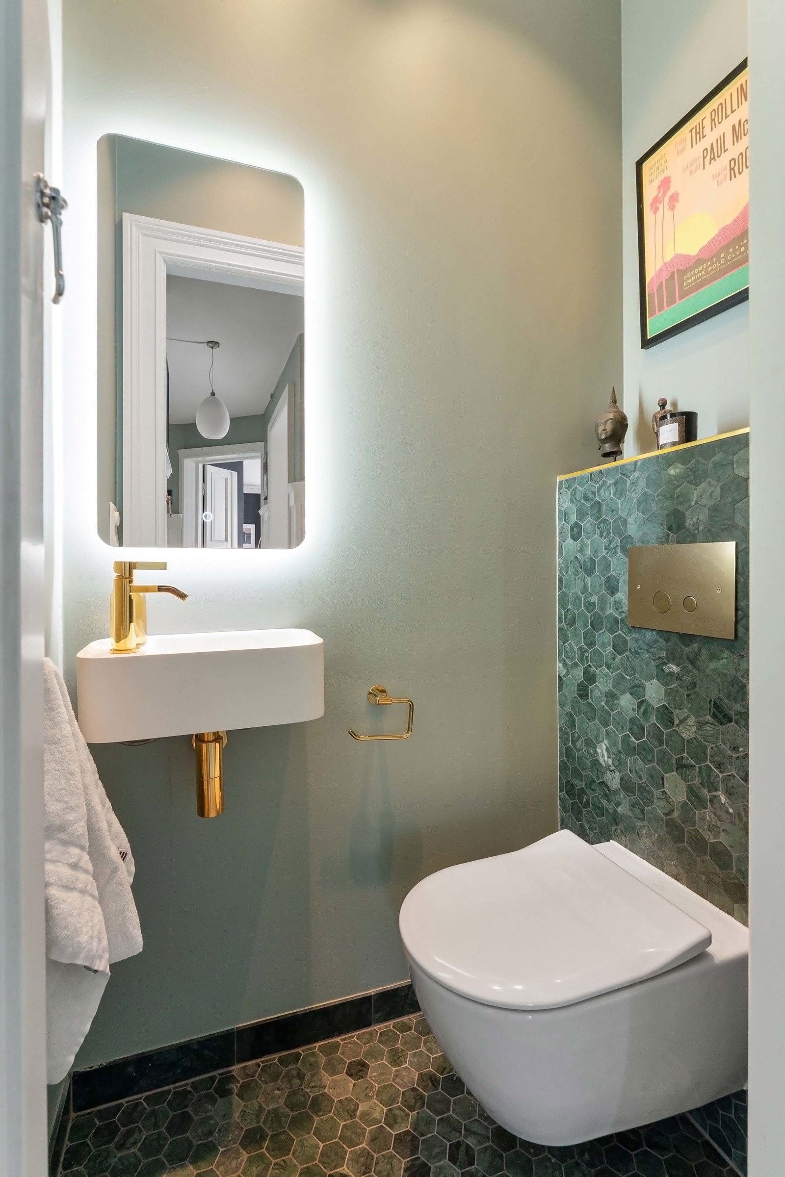 Toalettrommet er holdt i samme stil som badet med smaragdgrønn heksagonmosaikk på gulv og sisternekasse, lyse, grønne veggflater ellers og varmekabler i gulvet. Galleribilde