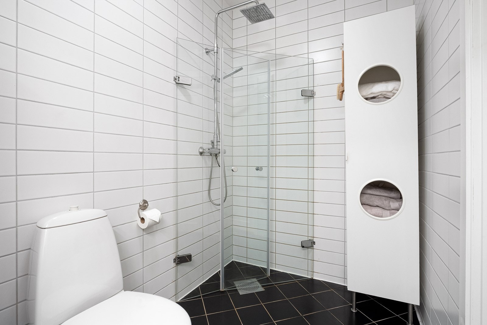 Helfliset bad utført med hvite og sorte fliser og varme i gulv. Galleribilde