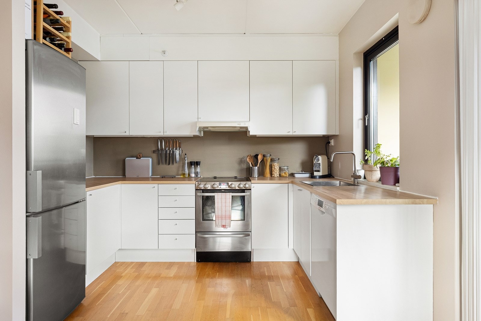 Kjøkken med stilrene overflater og rikelig med benk/skapplass. Galleribilde